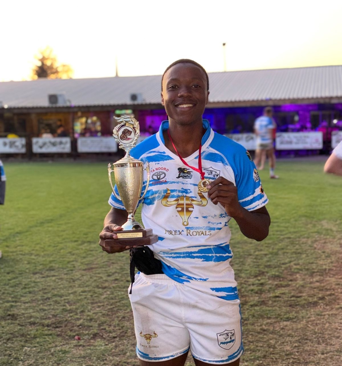 Nolo Buthelezi holding a 7s festival winners trophy and medal